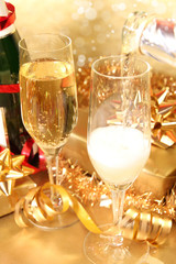 Glasses of champagne with golden decoration on background