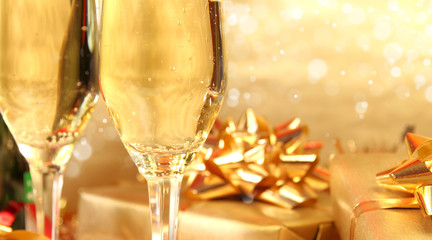 Glasses of champagne with golden decoration on background