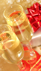 Glasses of champagne with golden decoration on background