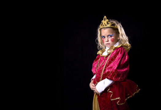 Adorable little girl in a princess costume on a black background