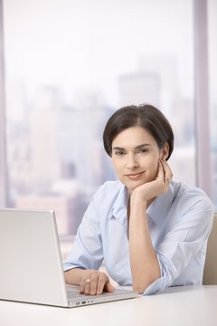 Portrait of female office worker with computer