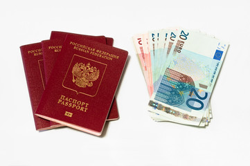 Two red passports and euro cash small banknotes on white