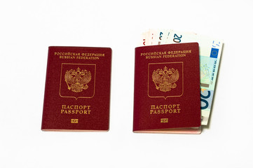 Two red passports and euro cash small banknotes on white