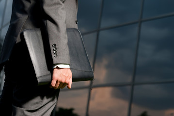 Unrecognizable businessman with suitcase working late concept