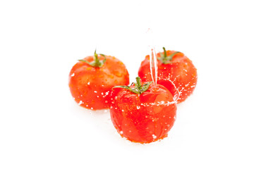 tomatoes under running water isolated on white