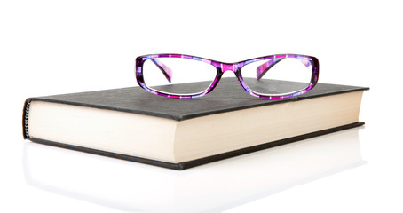 book with reading glasses over white background