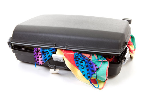 stuffed suitcase over white background