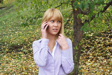 a young girl on nature speaks by phone