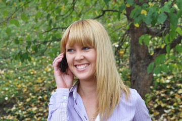 a young girl on nature speaks by phone
