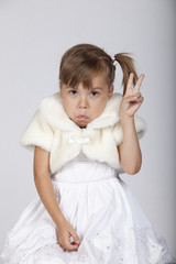 Very funny image of a shy little girl gesturing two fingers up