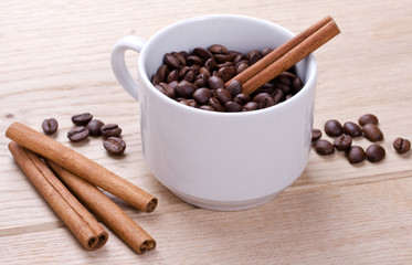 A cup of coffee on the table and cinnamon