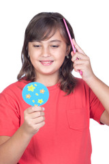 Preteen girl combing with a comb in front of a mirror