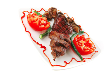 roast veal fillet on a plate with tomatoes