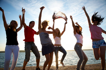 Obraz premium group of happy young people dancing at the beach