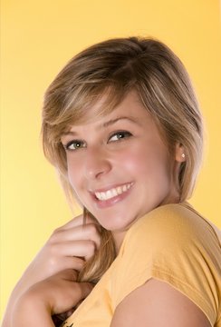 jeune femme souriante sur fond jaune