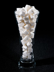 Glass of sugar tubes with dark background