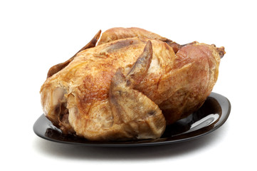 Tasty Crispy Roast Chicken on black plate .