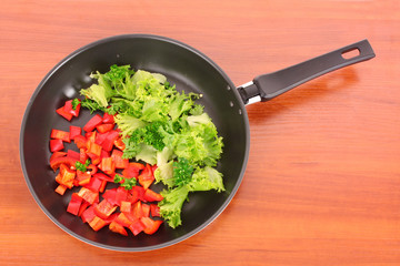 frying pan with vegetables  on the table