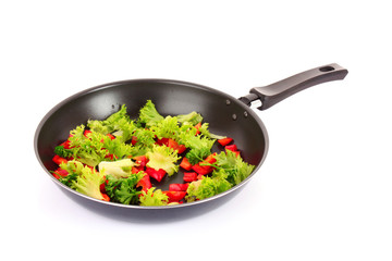 frying pan with vegetables  on white