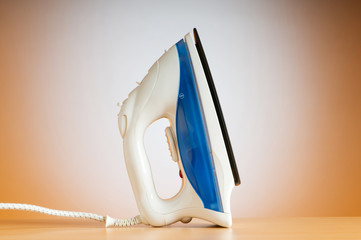 Modern electric iron against the colorful background