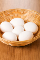 Many white eggs on the wooden table