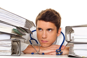 Arzt im Stress mit Akten Stapel. Bürokratie im Krankenhaus.