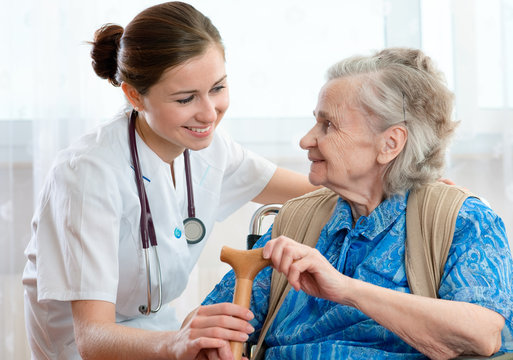 Senior woman is visited  by her doctor or caregiver