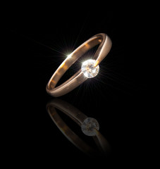 Gold ring with a brilliant on a black background