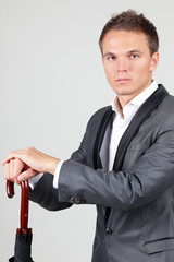Naklejka premium businessman in elegant suit with folded umbrella