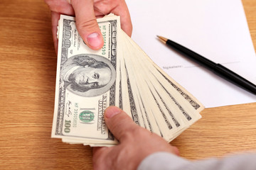 Businessmen passing money with contract on the background