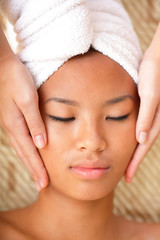 Obraz na płótnie Canvas Beautiful young woman receiving facial massage
