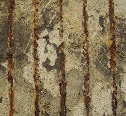 rusty metal embedded in a worn dirty concrete wall