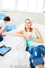 Relaxing smiling woman sitting on the sofa looking at the camera