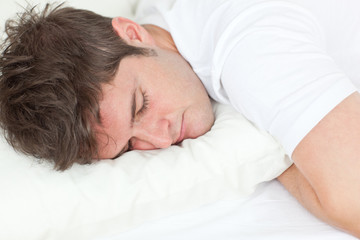 Fototapeta na wymiar Young caucasian man sleeping in his bed