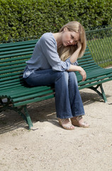 jeune fille triste sur un banc