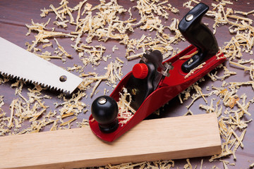 Red plane, wooden brick, handsaw and shavings