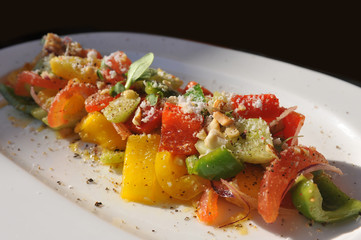 Salad with bell pepper, tomato and chicken on the white plate
