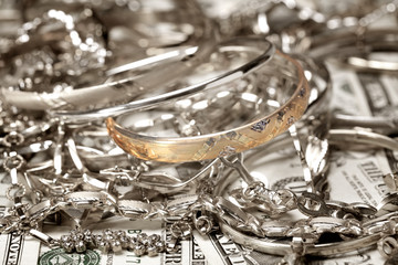 Golden bracelet  and other jewelry at money background
