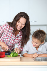 Mother cooking with son in kitchen