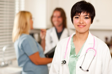 Fototapeta premium Pretty Doctor Smiles at Camera as Colleagues Talk