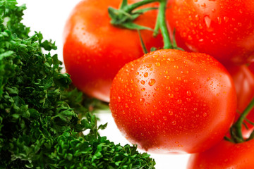 tomatoes and greens with water drops in a glass