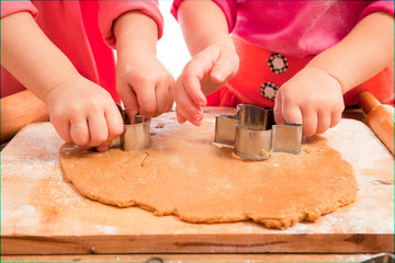 little girls cutting  gingerbread christmas cookies, hands only