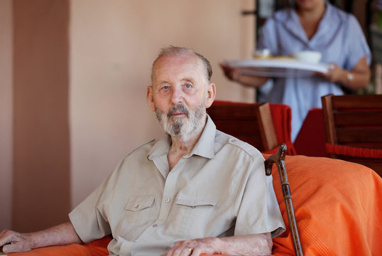 Senior Elderly Man With Carer Serving Meal