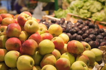 FRISCHE ÄPFEL UND ZWETSCHKEN IM HINTERGRUND