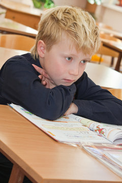 Sad schoolboy with a book