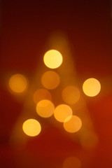 Unscharfer, leuchtender goldener Stern auf rotem Fond