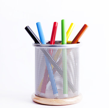 Black metal pencil cup filled with colorful pencils.