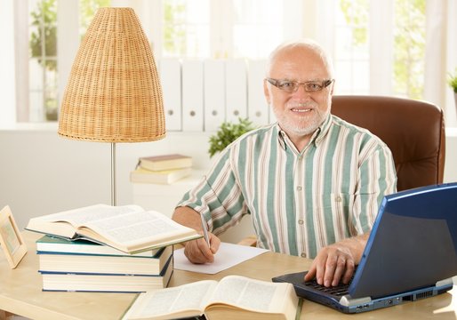 Portrait of senior professor sitting at desk