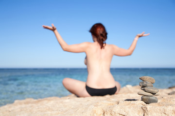 Fototapeta na wymiar Balanced stones and girl doing yoga