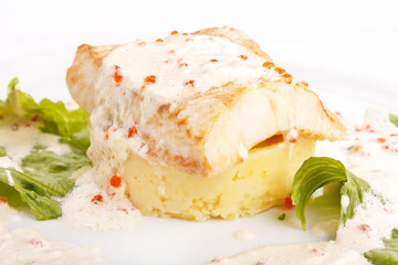 fish fillet with dill sauce on white plate